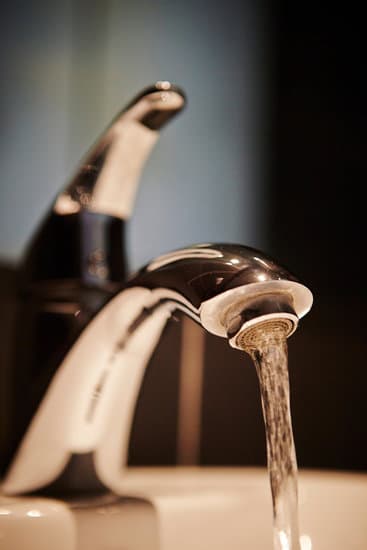 Water is running from a silver faucet tap