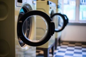 A row of launderette washing machines with their doors open