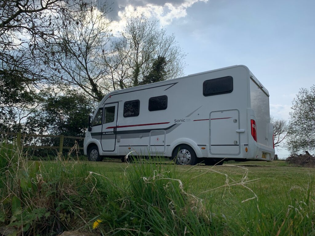 An A class Motorhome is parked on a grass field