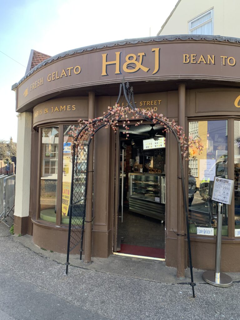 H&J coffee shop and ice cream parlour. The exterior is brown with a flower garland entrance way