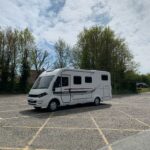 An A class Motorhome is parked in a concrete car park