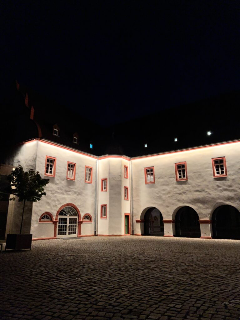 It is night, there is a white building, beautifully illuminated