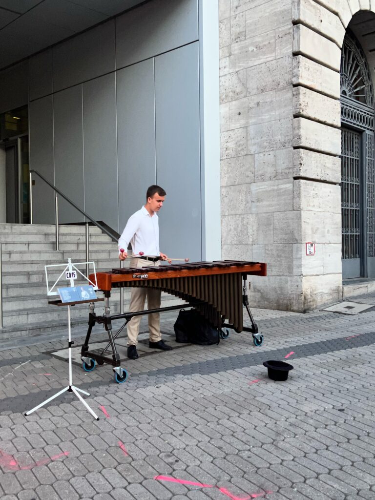 A street performer is playing a giant glockenspiel