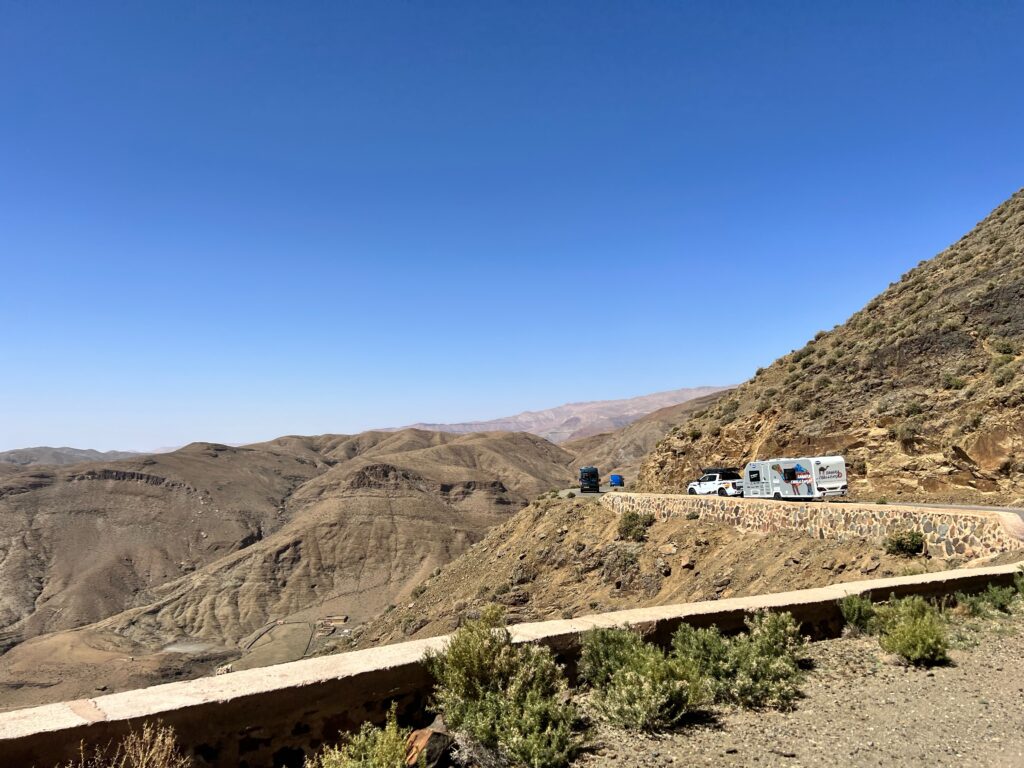 The view from the cab of a motorhome, showing the huge expanse of land around the mountain roads