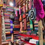 a shot of a shop in Medina de Fez displaying the various brightly covered scarves, bags and textiles
